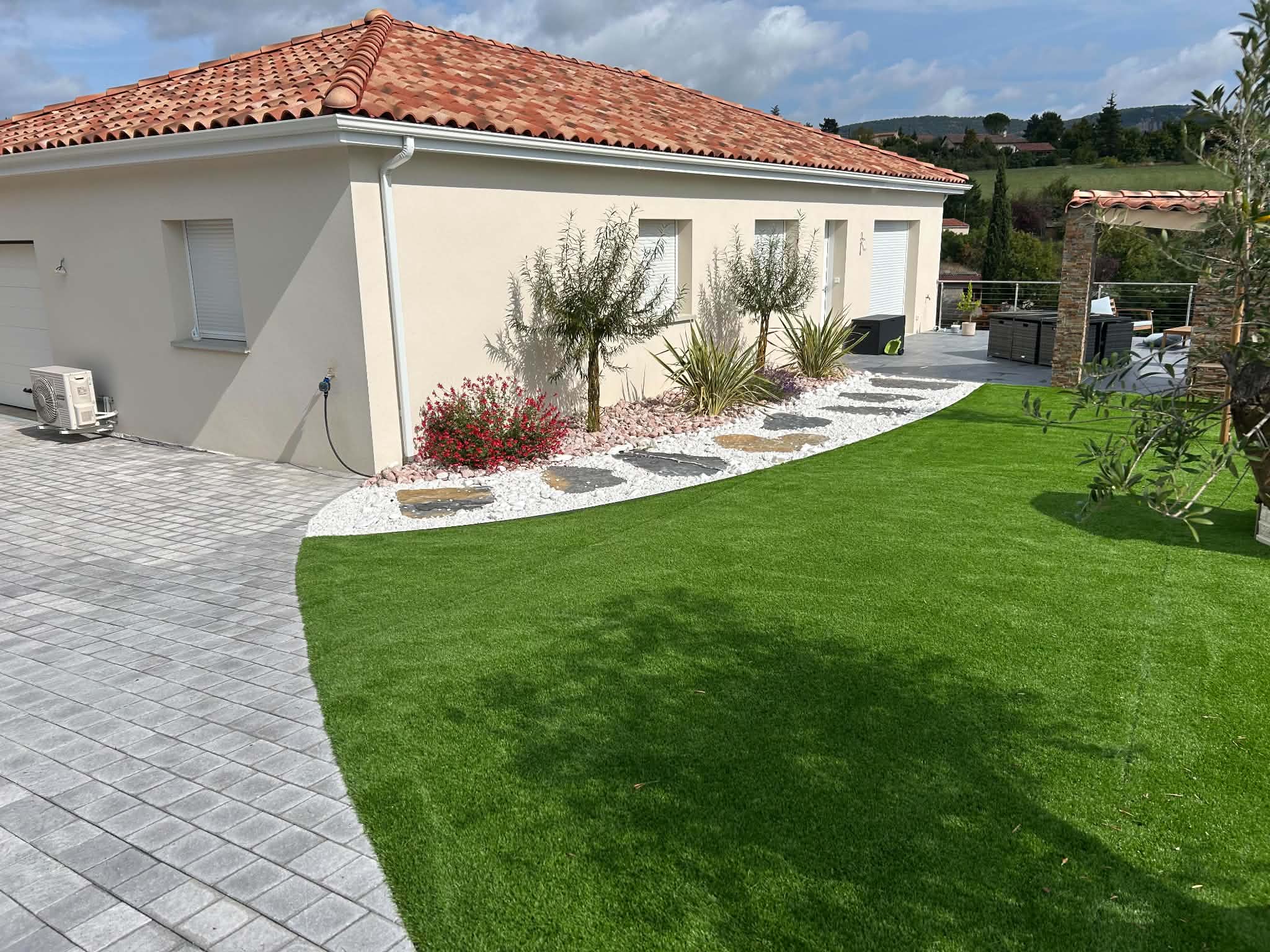 Terrasse, pelouse synthétique et allée pavée